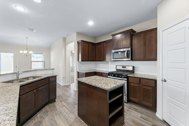 kitchen featuring sink, pendant lighting, dark brown cabinets, and appliances with stainless steel finishes