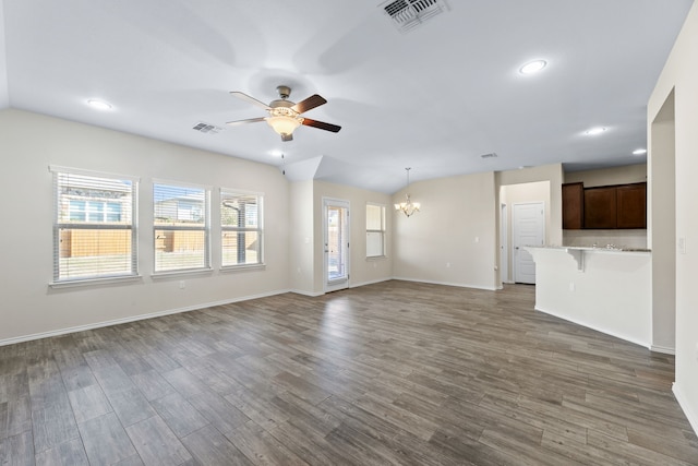 unfurnished living room featuring dark hardwood / wood-style flooring and ceiling fan with notable chandelier