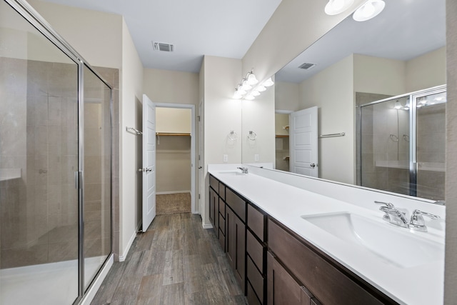 bathroom with hardwood / wood-style floors, vanity, and walk in shower