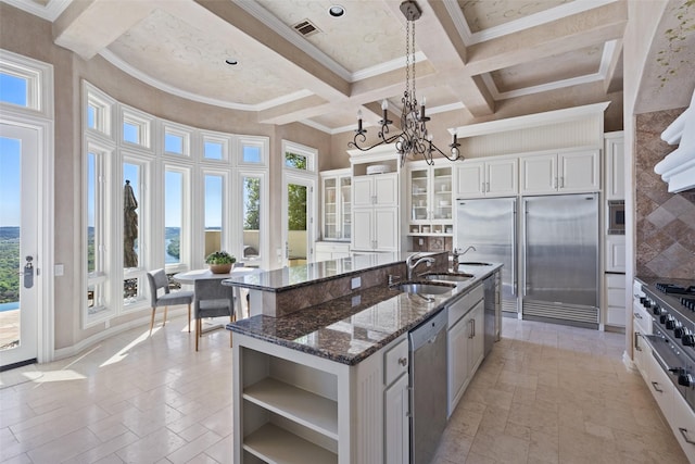 kitchen featuring sink, coffered ceiling, beamed ceiling, an island with sink, and appliances with stainless steel finishes