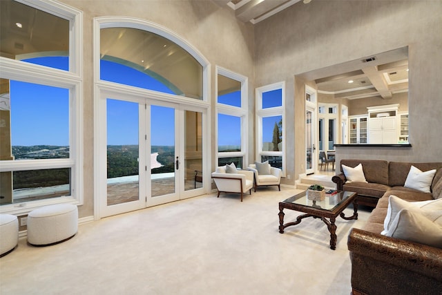 carpeted living room with a high ceiling, french doors, and coffered ceiling