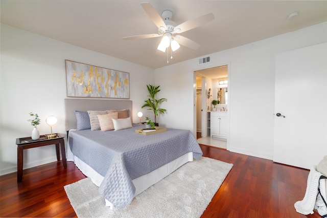 bedroom with ceiling fan, dark hardwood / wood-style floors, and connected bathroom