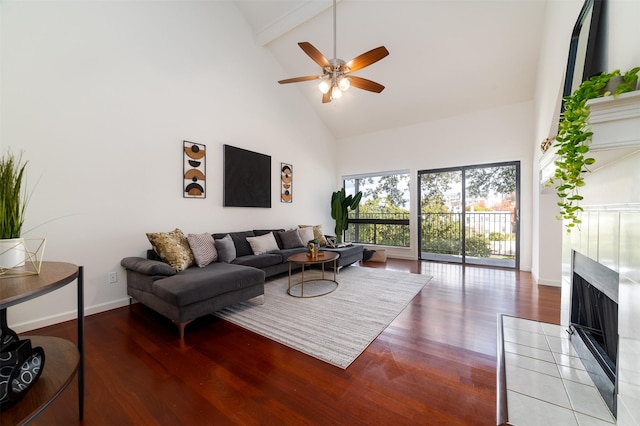 living room with ceiling fan, a fireplace, high vaulted ceiling, and hardwood / wood-style floors