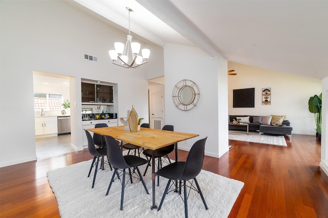 dining space with beam ceiling, a chandelier, high vaulted ceiling, and light hardwood / wood-style floors