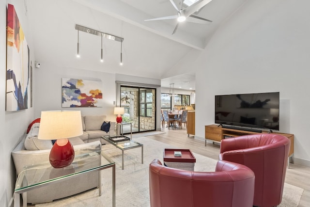 living room with high vaulted ceiling, beam ceiling, light hardwood / wood-style floors, and ceiling fan