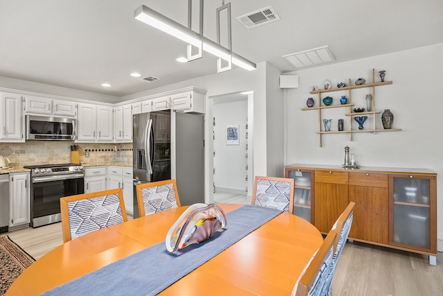 dining area with recessed lighting, visible vents, and light wood-style flooring