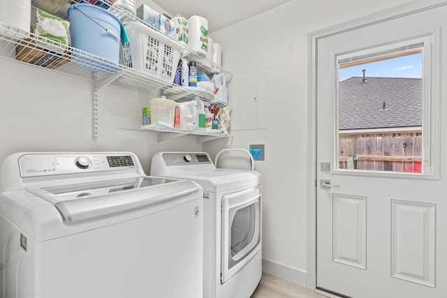 washroom featuring light wood-type flooring, laundry area, washer and clothes dryer, and baseboards