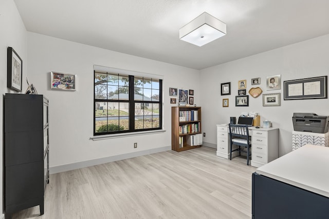 office area with light wood-style floors and baseboards