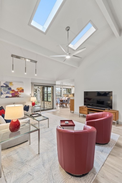 living room featuring high vaulted ceiling, light wood-type flooring, beam ceiling, and a skylight