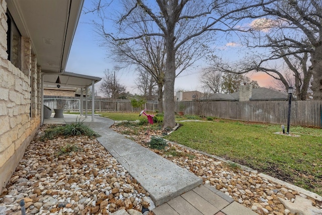 yard at dusk with a patio and a fenced backyard