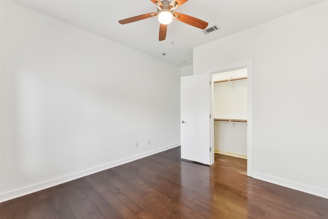 unfurnished bedroom with a closet, dark hardwood / wood-style floors, and ceiling fan