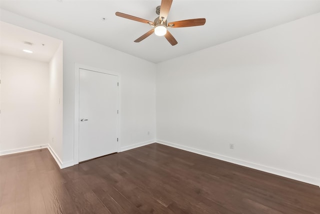 spare room with dark hardwood / wood-style floors and ceiling fan