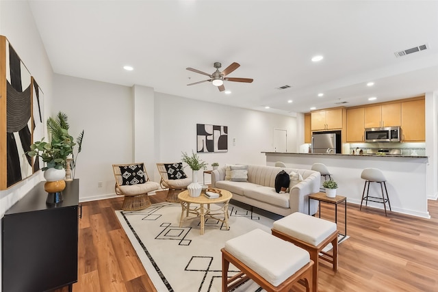 living room featuring ceiling fan and light hardwood / wood-style flooring