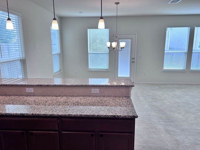 kitchen featuring dark brown cabinets, an inviting chandelier, and hanging light fixtures