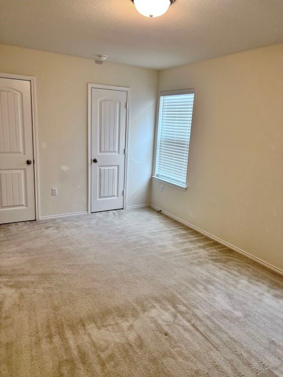 unfurnished room with light carpet