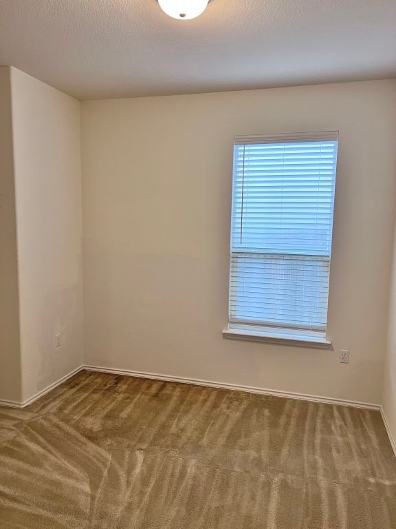 carpeted spare room with a textured ceiling