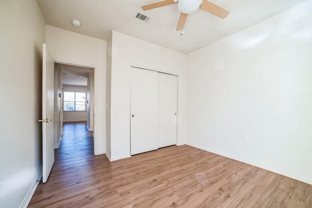 unfurnished bedroom featuring ceiling fan, light wood-type flooring, and a closet