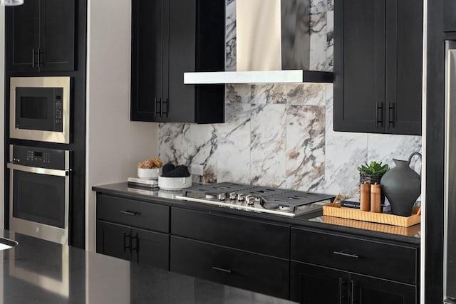 kitchen featuring wall chimney exhaust hood, backsplash, and appliances with stainless steel finishes