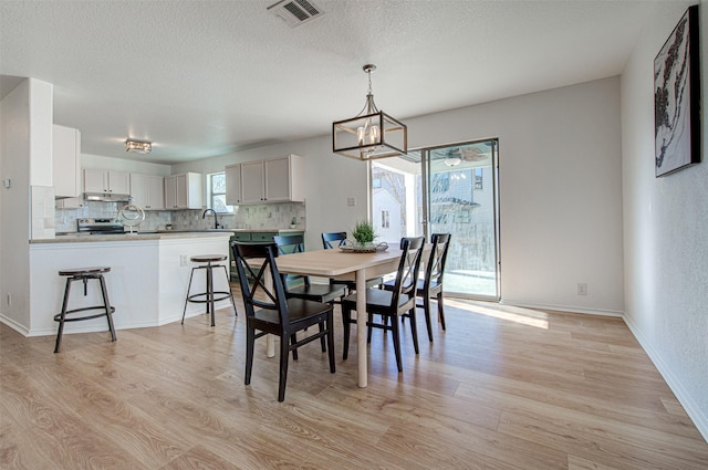 dining area with light hardwood / wood-style floors and sink