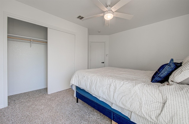 bedroom with ceiling fan, light colored carpet, and a closet