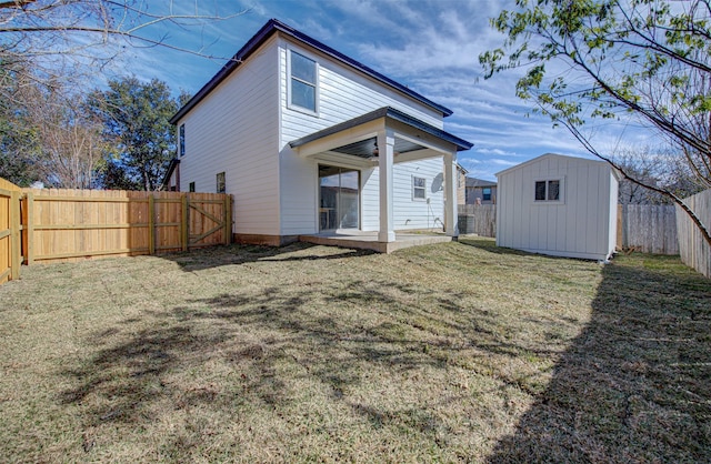 rear view of house featuring a yard, a storage unit, and a patio area