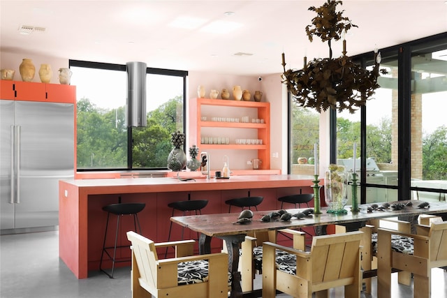 kitchen featuring a wealth of natural light, high end fridge, and a breakfast bar area