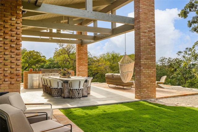 view of patio with area for grilling and a pergola