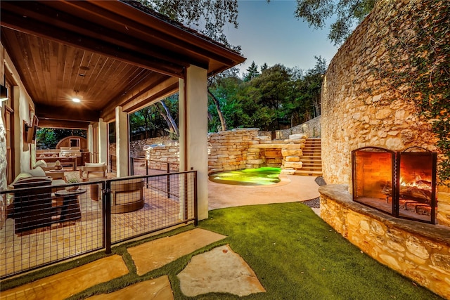 exterior space with an outdoor stone fireplace and exterior kitchen