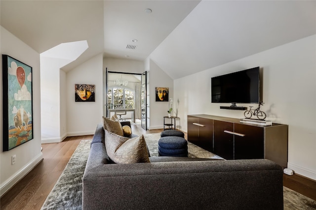 living room with a chandelier, wood-type flooring, and vaulted ceiling