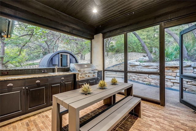 sunroom featuring wooden ceiling and sink