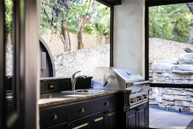 view of patio with an outdoor kitchen, sink, and grilling area