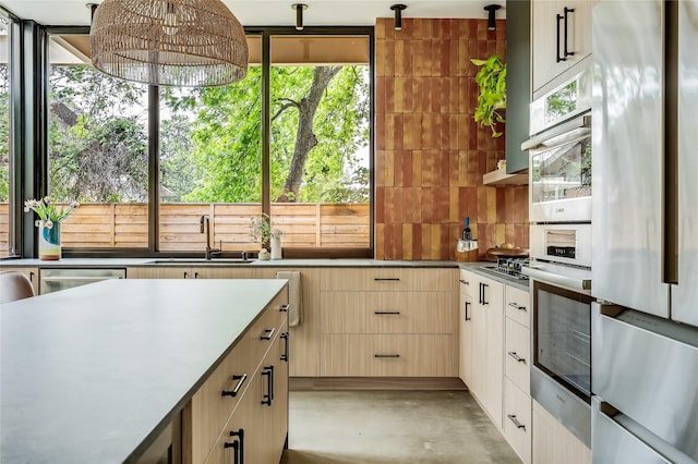 kitchen with decorative light fixtures, stainless steel appliances, a healthy amount of sunlight, and sink