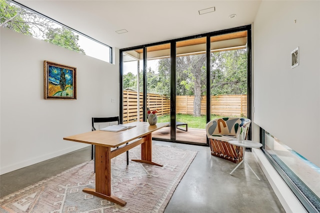 office space featuring floor to ceiling windows and concrete flooring