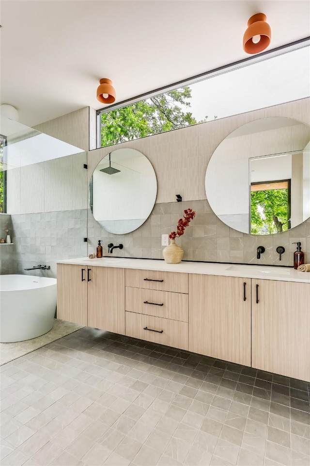 bathroom featuring backsplash, tile patterned flooring, vanity, and a washtub