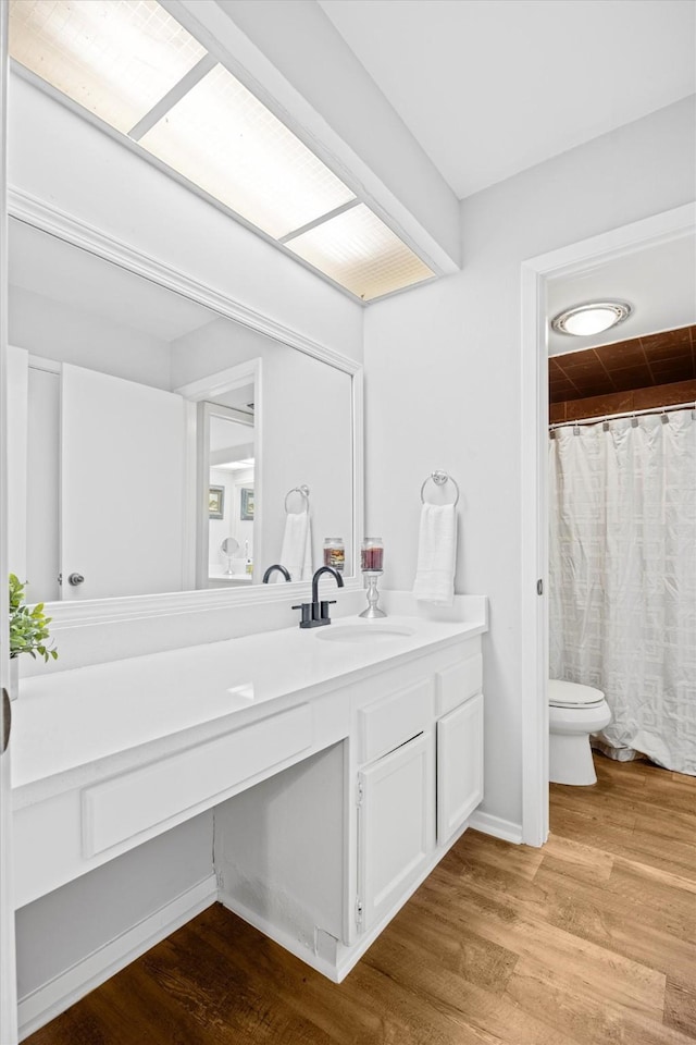 bathroom featuring toilet, vanity, and hardwood / wood-style flooring