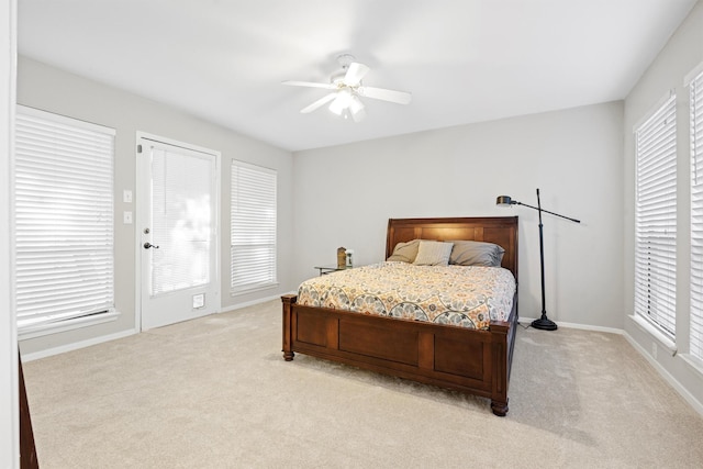 bedroom with light carpet, multiple windows, and ceiling fan