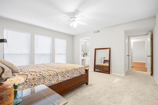 bedroom featuring ceiling fan, light carpet, and connected bathroom