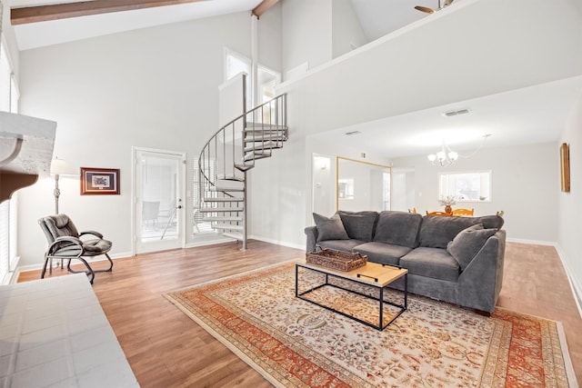 living area featuring baseboards, a chandelier, stairway, beam ceiling, and wood finished floors