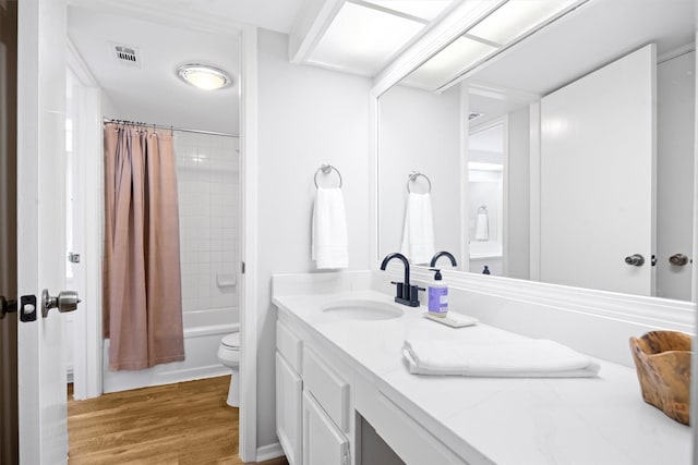 full bathroom with vanity, wood-type flooring, shower / bath combo, and toilet