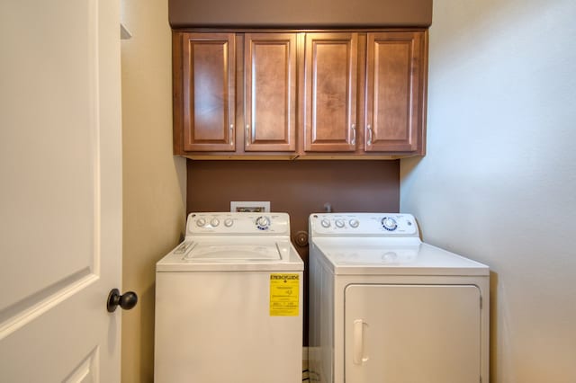 laundry area with washer and dryer and cabinets