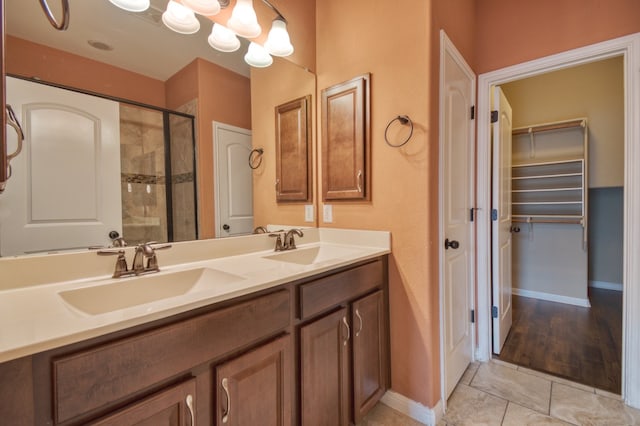 bathroom with tile patterned floors, walk in shower, and vanity