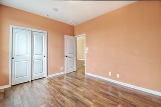 unfurnished bedroom with hardwood / wood-style floors and a closet