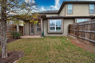 back of property featuring a patio area and a lawn