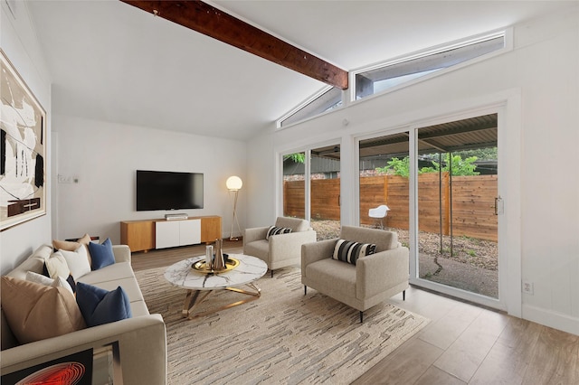 living room featuring lofted ceiling with beams and light hardwood / wood-style floors