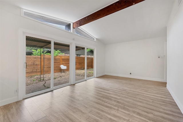 empty room with lofted ceiling with beams and light hardwood / wood-style floors