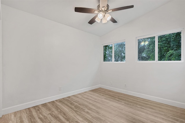 spare room with light hardwood / wood-style flooring, vaulted ceiling, and ceiling fan