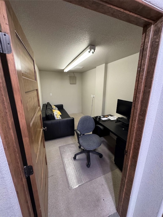 carpeted office space featuring a textured ceiling