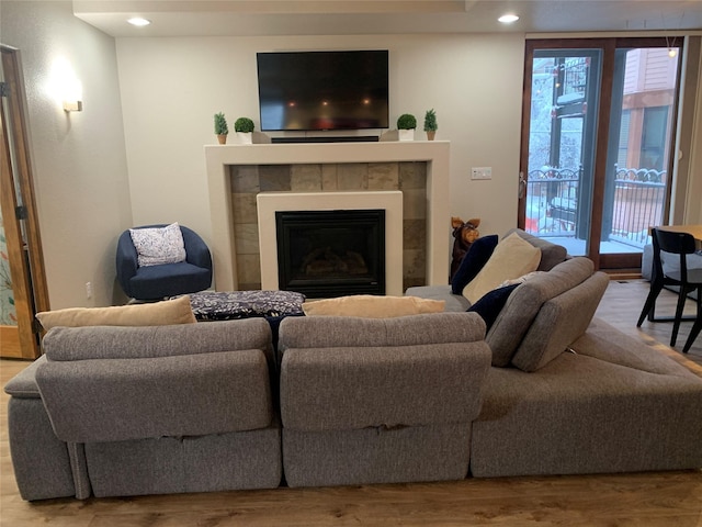 living room with light wood-type flooring and a tile fireplace