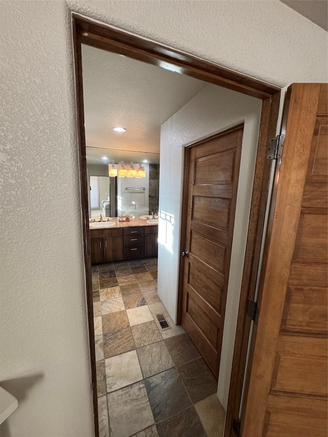 bathroom with vanity and a textured ceiling