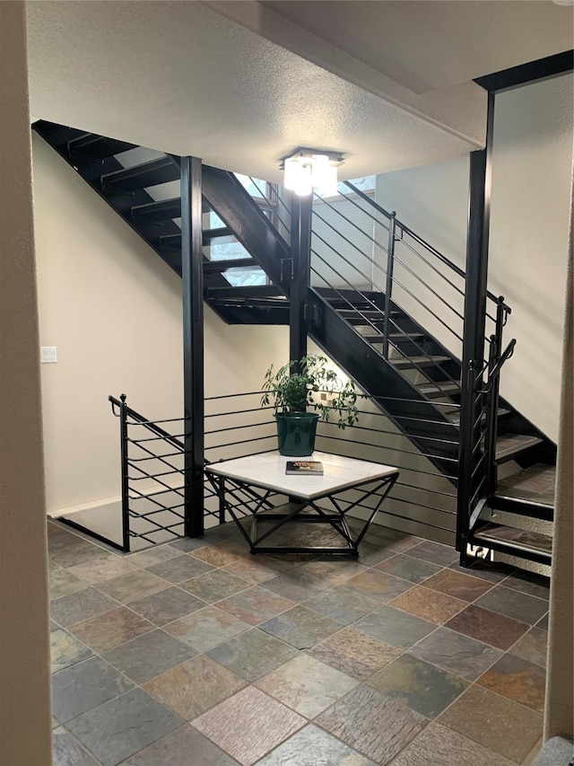 stairs featuring a textured ceiling